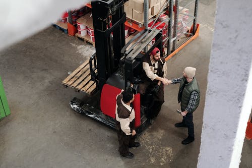 warehouse workers shaking hands and talking