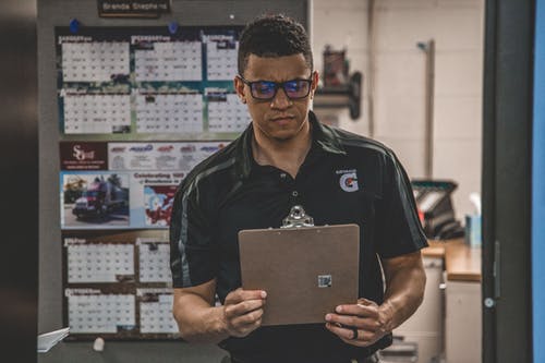 warehouse worker holding and looking at clipboard