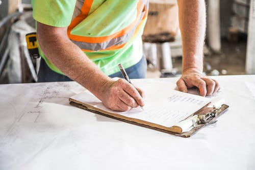 man-writing-on-clipboard