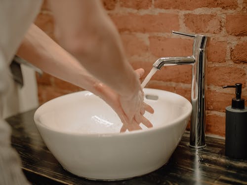 person washing their hands at sink