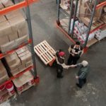 two warehouse workers shaking hands