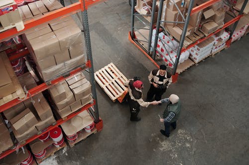 two warehouse workers shaking hands