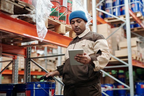 warehouse worker checking inventory with tablet