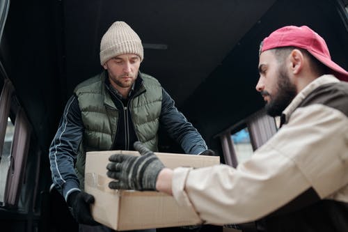 one worker passing a box to another