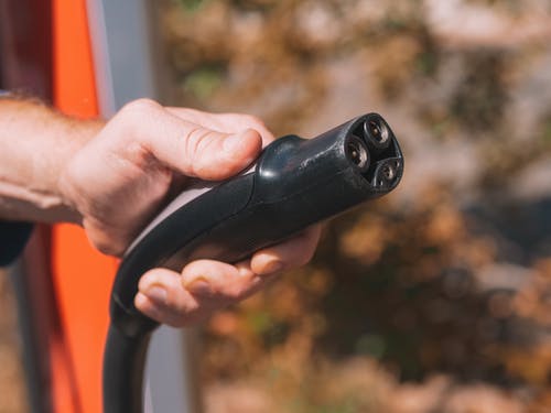 person holding electric car charger