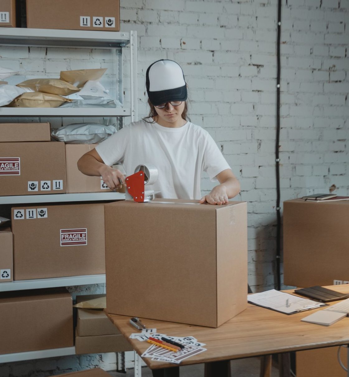 person taping a box shut on a table